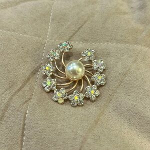 A lovely rose gold pin with sparkly rhinestones and a big pearl center.